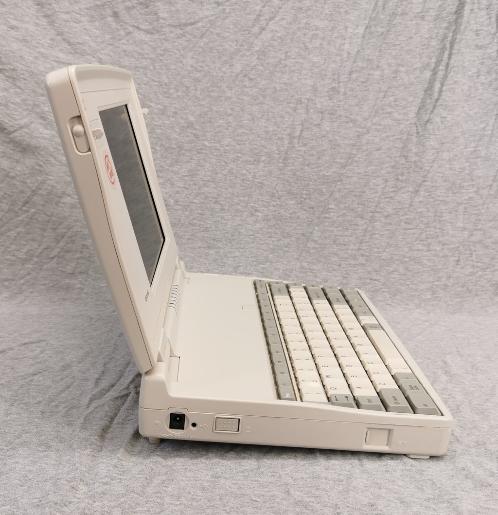 Toshiba T1950CT from left side with extending feet deployed showing how rear of machine is raised