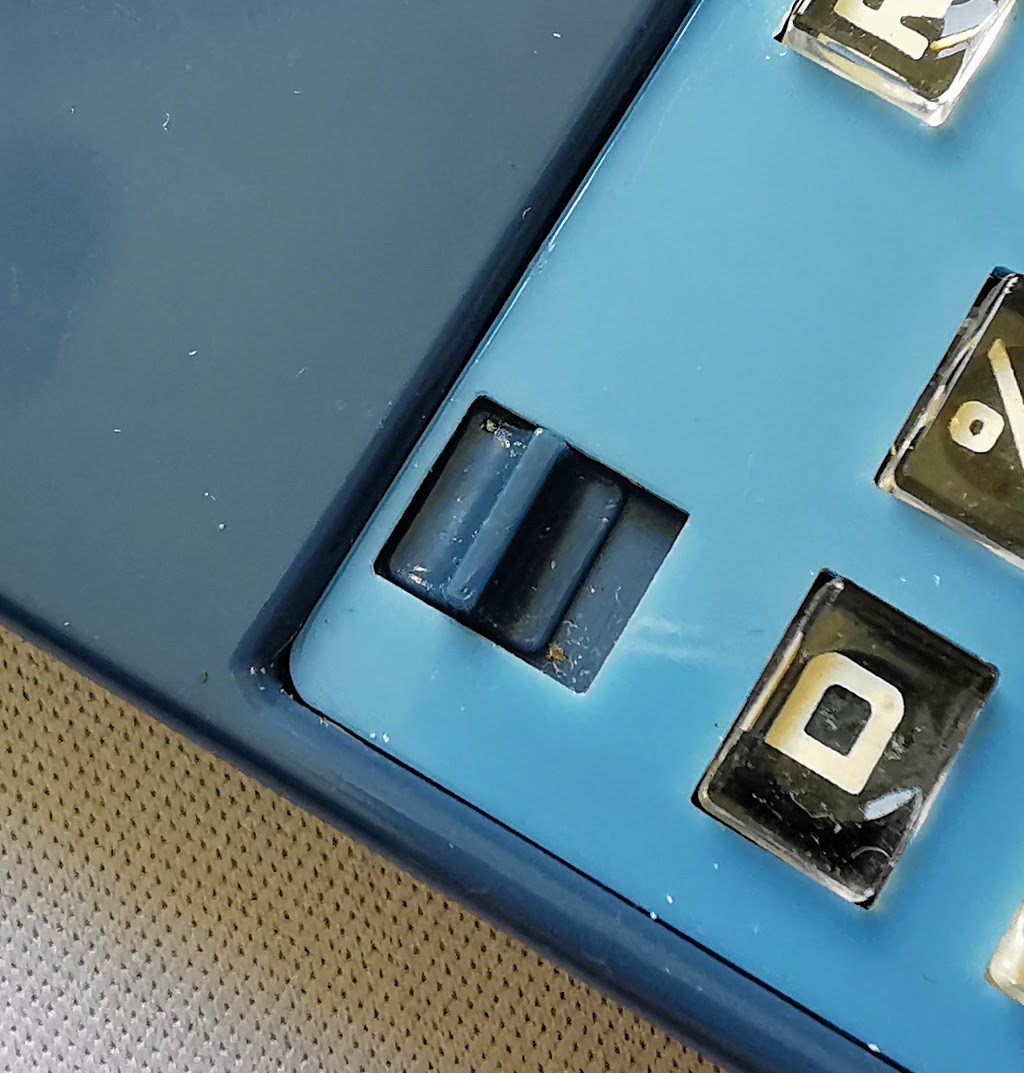 Closeup of main power switch and display wake up (D) key on Prinztronic Mini 7 Calculator