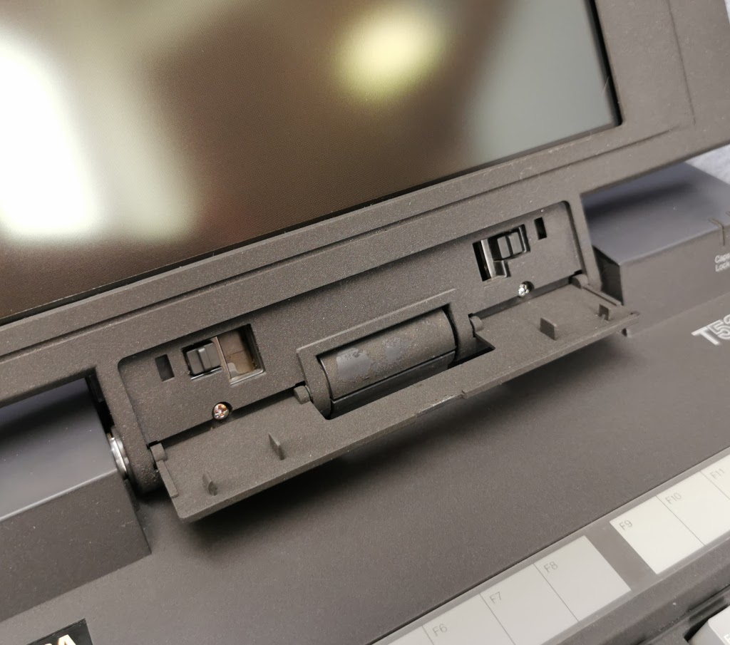 Detail of the front display securing screws and latches on a Toshiba T5200