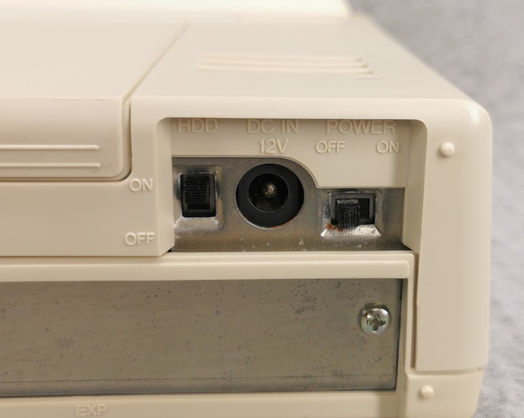 Detail of power input jack and switches on a Toshiba T1200