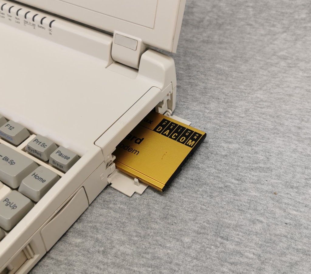 PCMCIA expansion slot cover on Toshiba T1950CT open and modem card partially removed